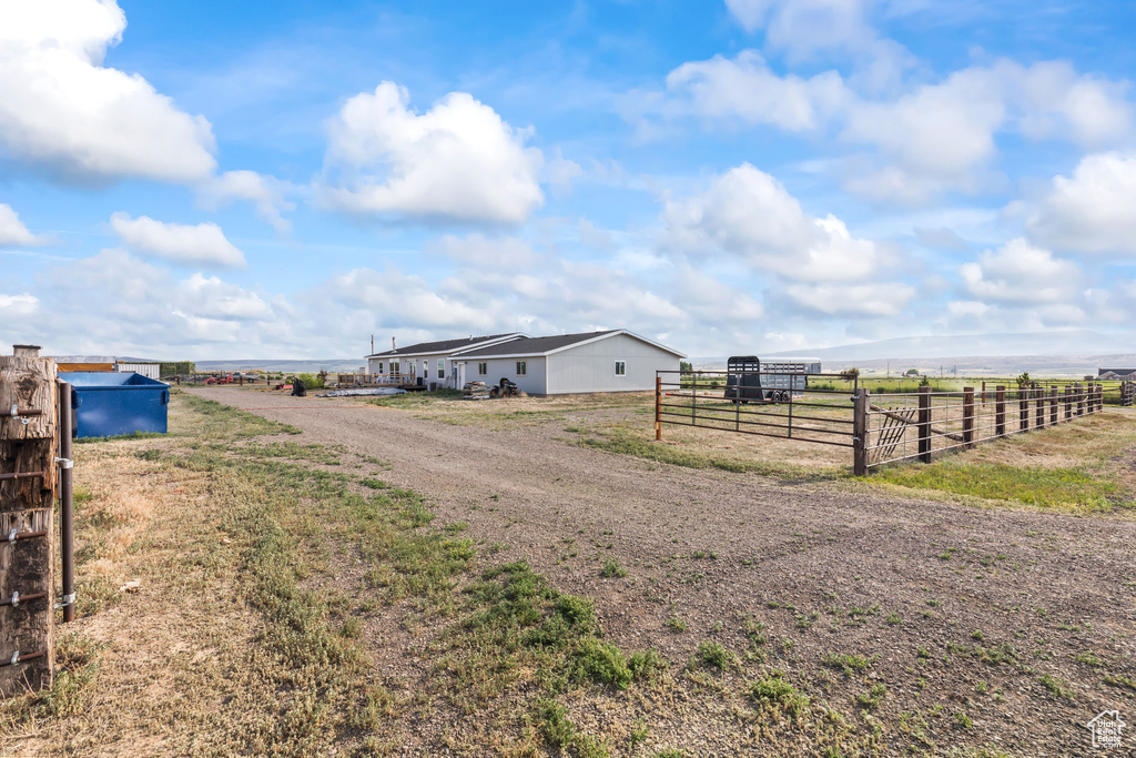 View of dirt / gravel road featuring a view of rural / pastoral area