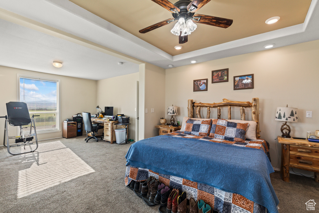 Carpeted bedroom featuring an office area, recessed lighting, ceiling fan, and a tray ceiling