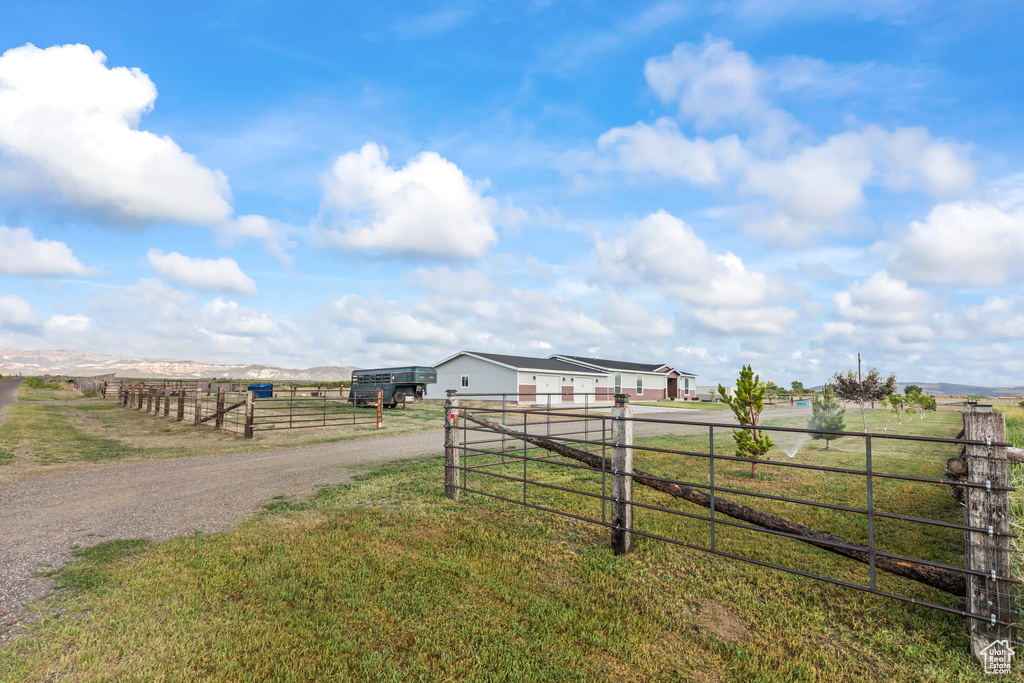 View of dirt / gravel road with a rural view and a gated entry