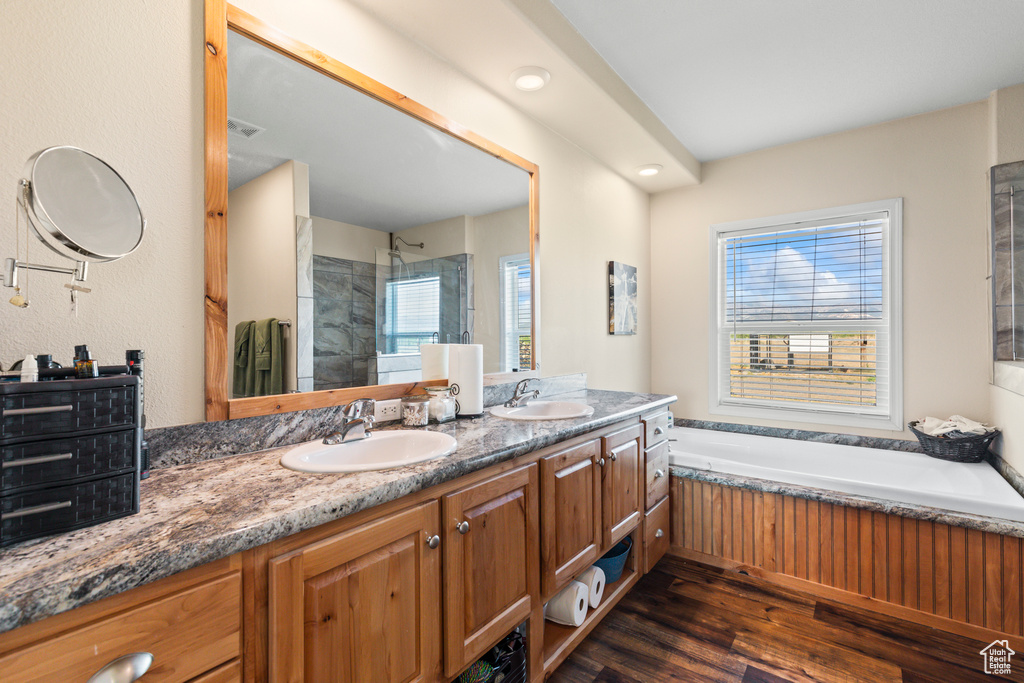 Bathroom with a shower stall, plenty of natural light, a garden tub, and double vanity