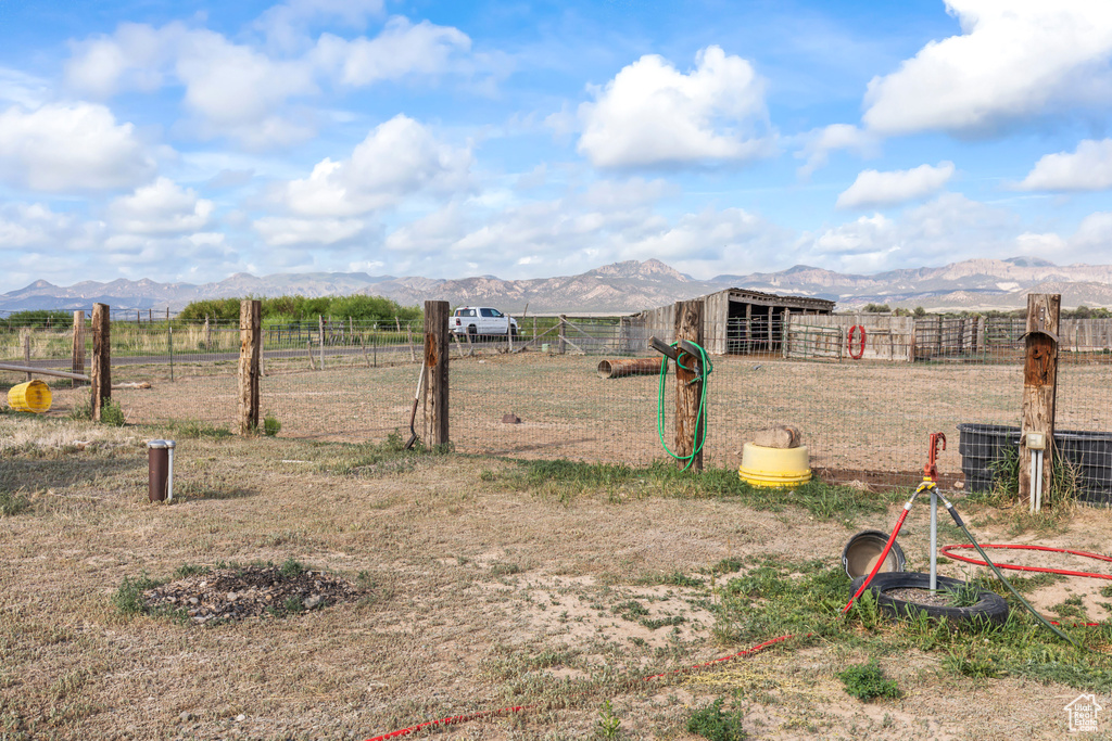 View of yard with a mountain view, an outdoor structure, an exterior structure, and a rural view