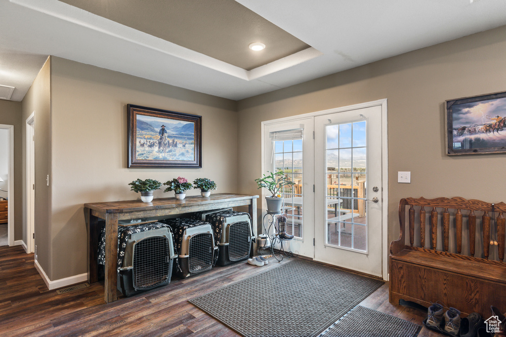 Entryway featuring dark wood-style flooring, a raised ceiling, and recessed lighting