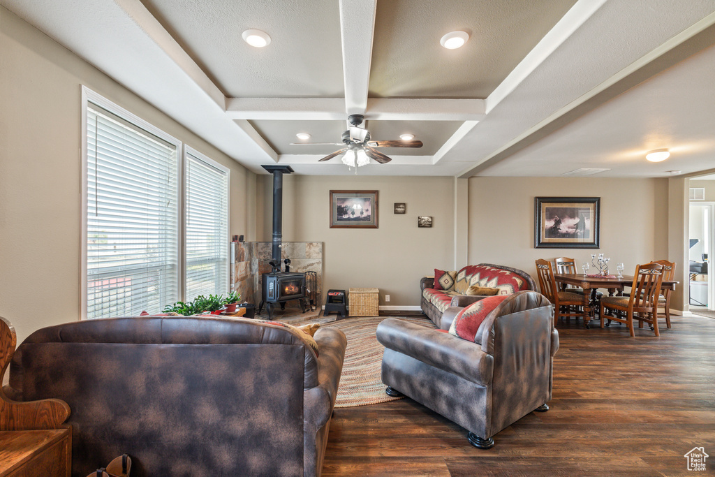 Living room with a wood stove, dark wood finished floors, coffered ceiling, a ceiling fan, and recessed lighting
