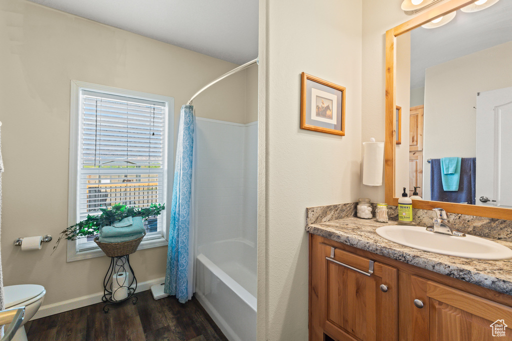 Bathroom featuring vanity, wood finished floors, and shower / tub combo