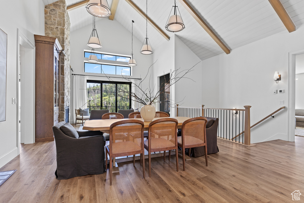 Dining area featuring high vaulted ceiling, beamed ceiling, and wood finished floors