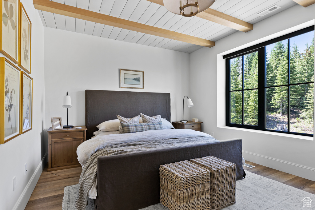 Bedroom featuring wood finished floors and a wood ceiling with exposed beams