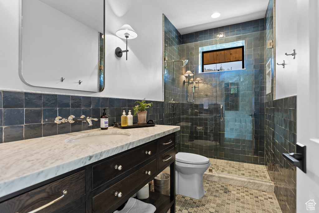 Bathroom with vanity, walk in shower, tile walls, and tile patterned floors