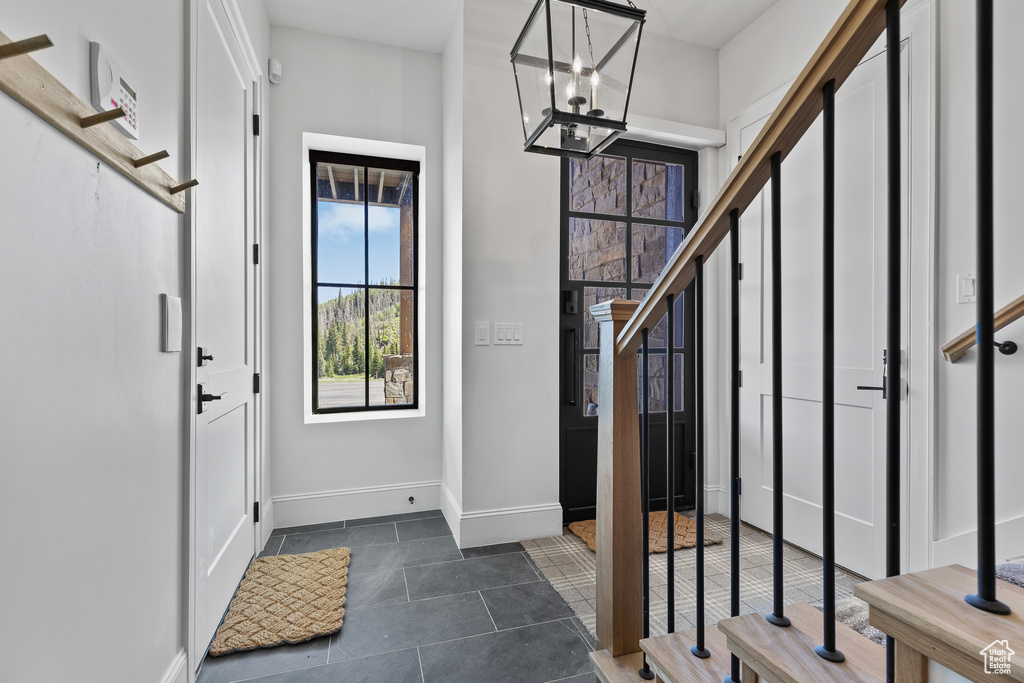 Foyer entrance featuring a chandelier and dark tile patterned floors