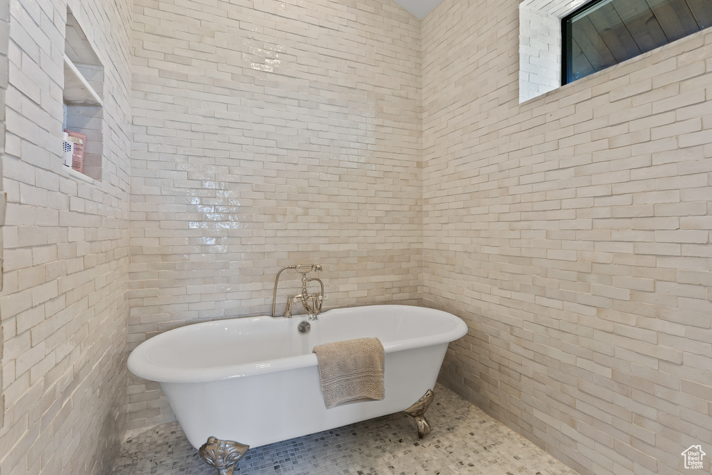Bathroom with brick wall and a soaking tub