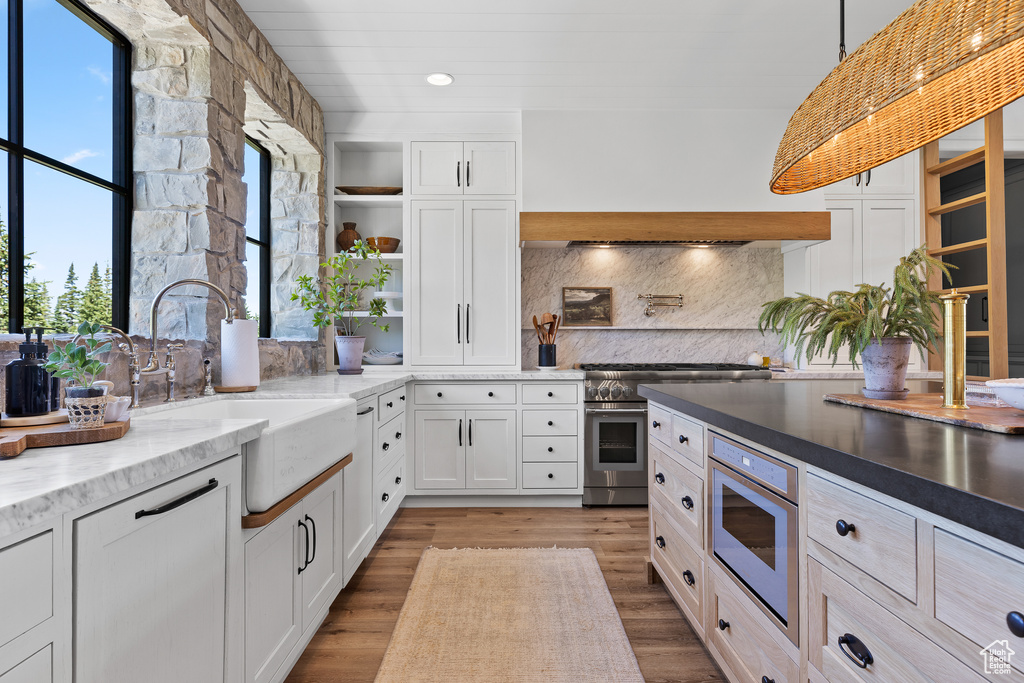Kitchen featuring double oven range, open shelves, backsplash, white cabinets, and recessed lighting