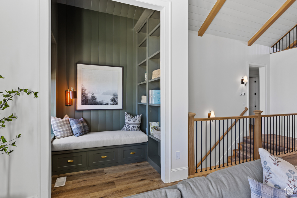 Living area featuring an upstairs landing, wood finished floors, and wooden ceiling