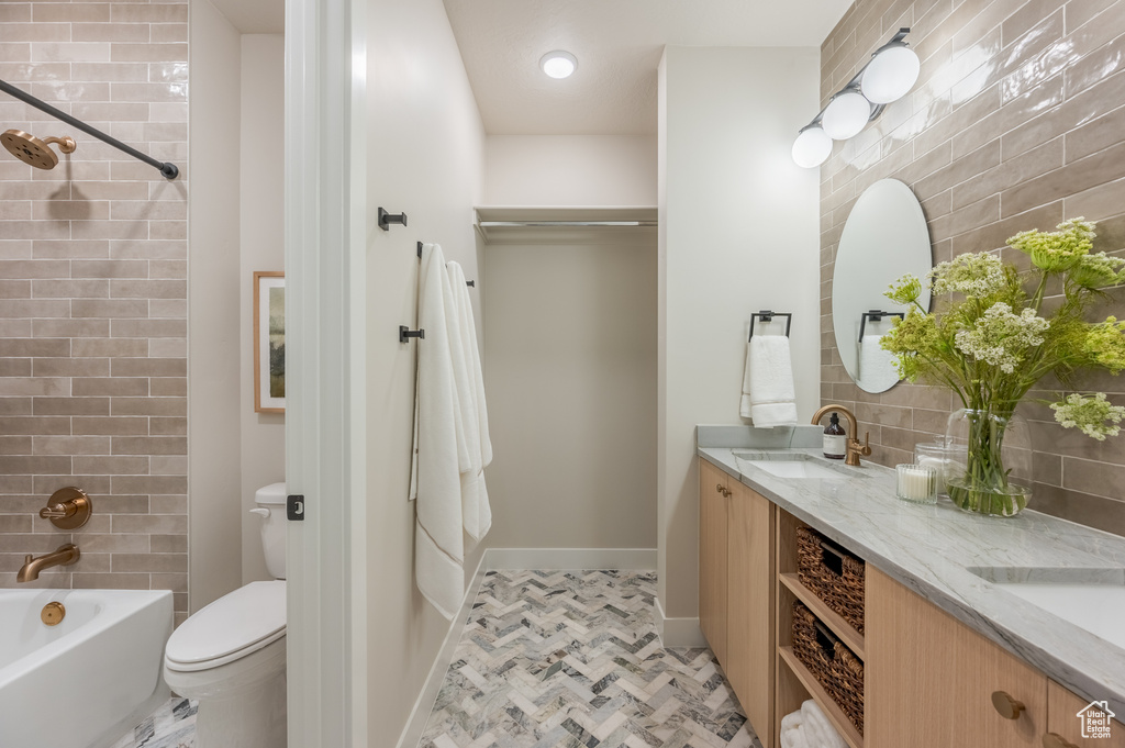 Bathroom featuring double vanity and bathing tub / shower combination