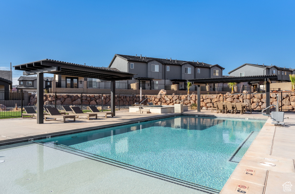 Community pool with a pergola, a patio area, and a residential view