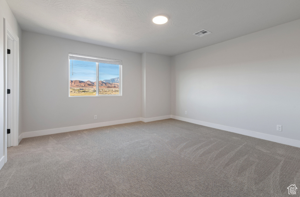 Spare room with light colored carpet and baseboards