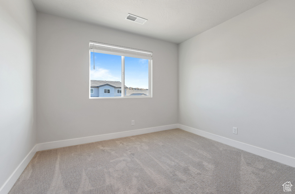 Carpeted spare room with baseboards