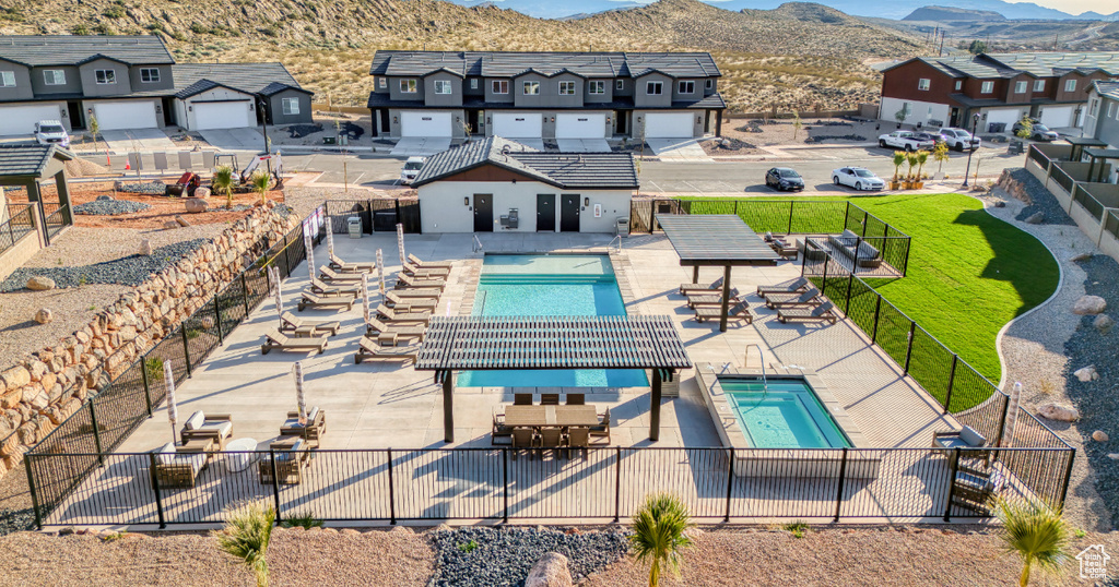 Community pool with a fenced backyard, a residential view, a mountain view, and a patio area