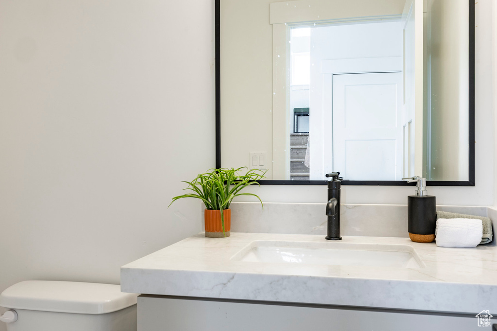 Half bathroom featuring toilet and vanity