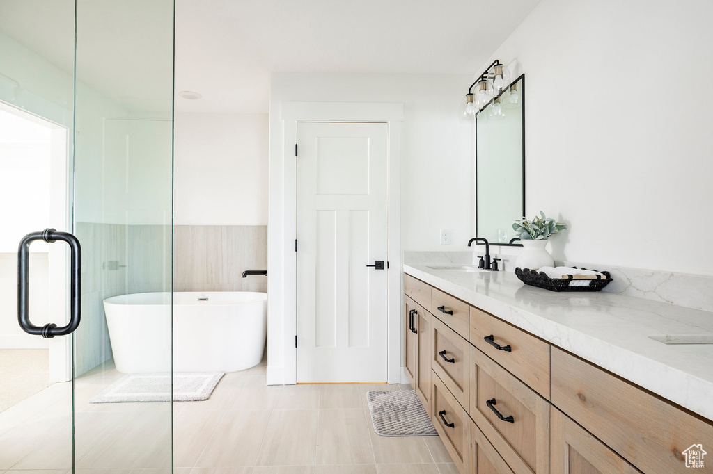 Full bathroom featuring double vanity and a soaking tub