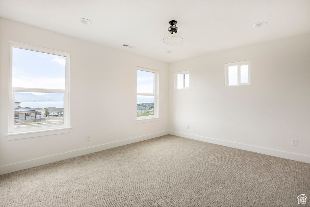 Spare room featuring baseboards and light carpet