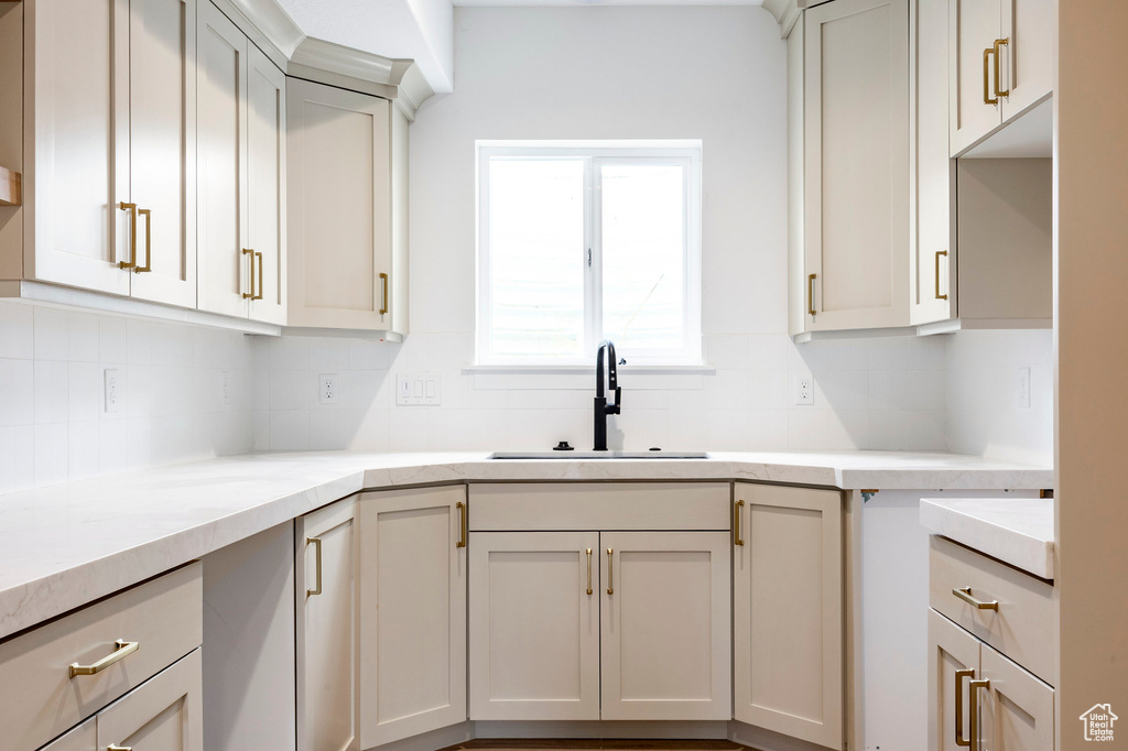 Kitchen with tasteful backsplash and light stone counters