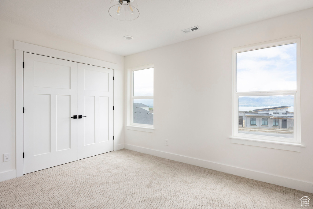 Unfurnished bedroom with carpet flooring and a closet