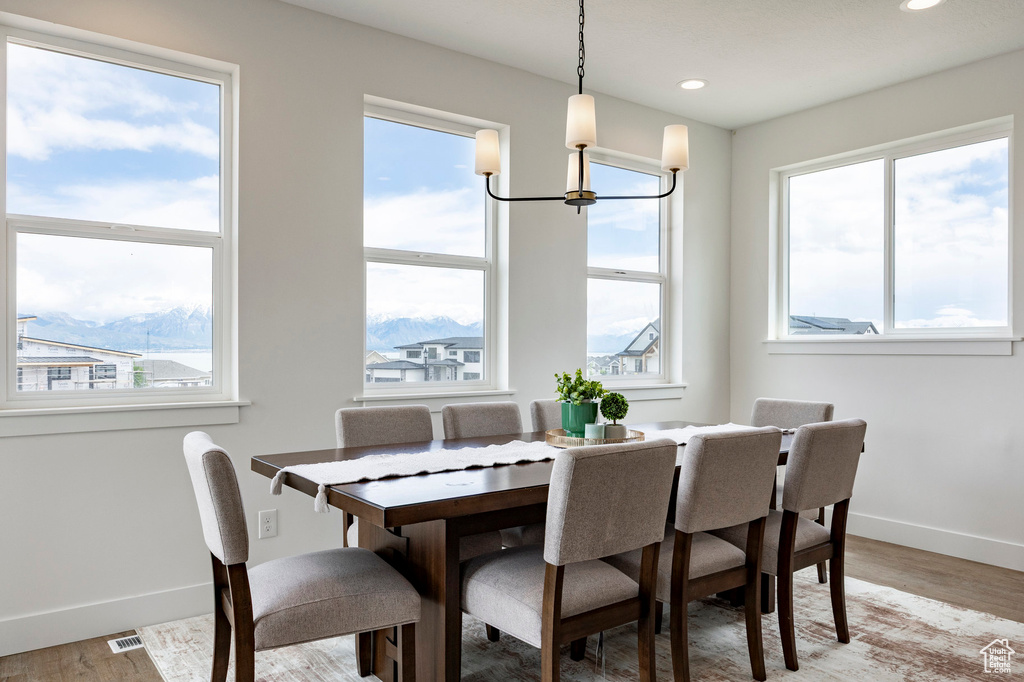 Dining area with plenty of natural light, recessed lighting, light wood-style flooring, and a chandelier