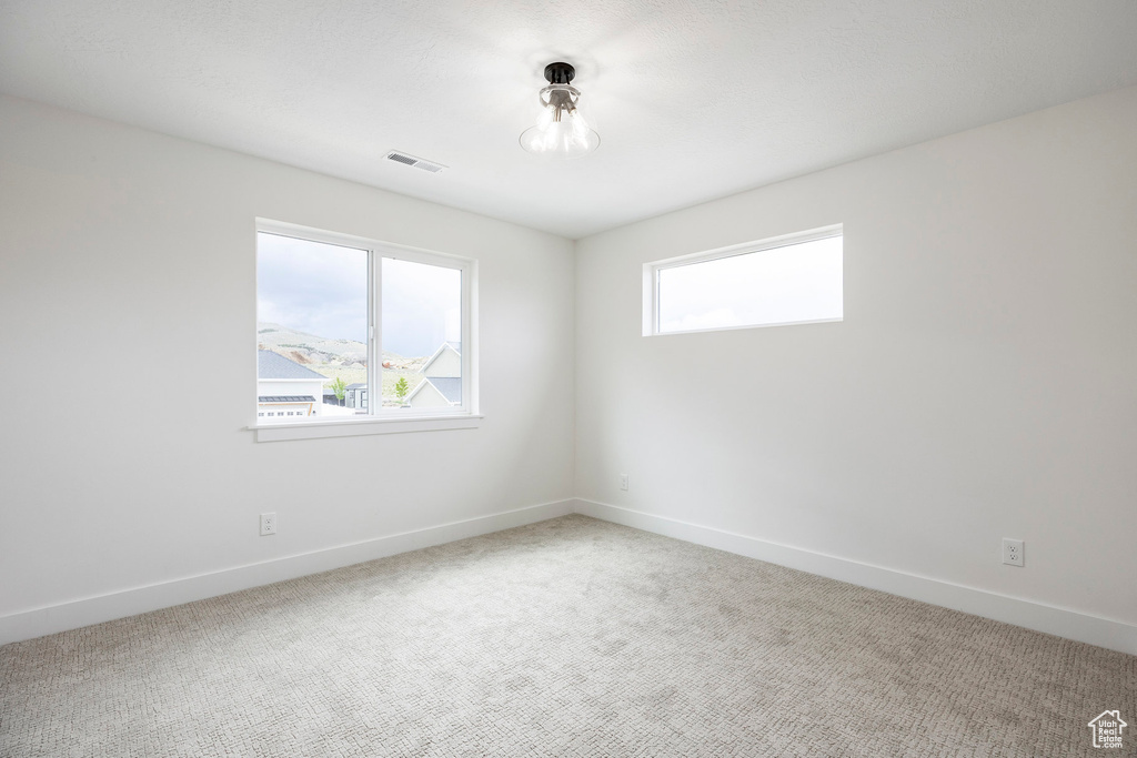 Carpeted empty room featuring baseboards