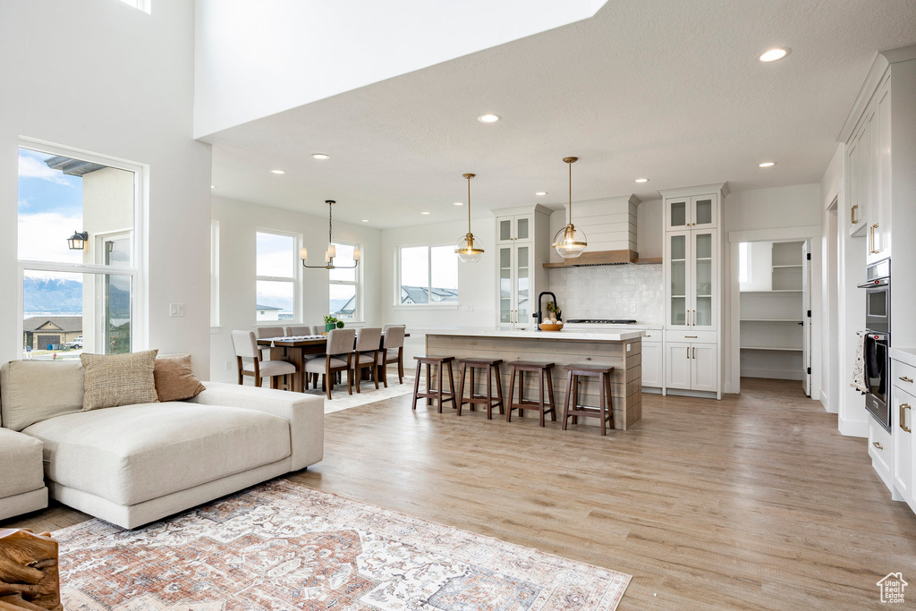 Living room with light wood-style floors, recessed lighting, and a chandelier