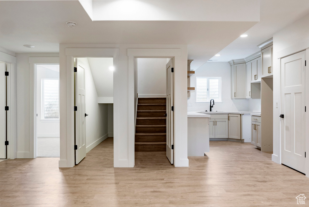 Kitchen featuring light wood finished floors, recessed lighting, light countertops, and open shelves