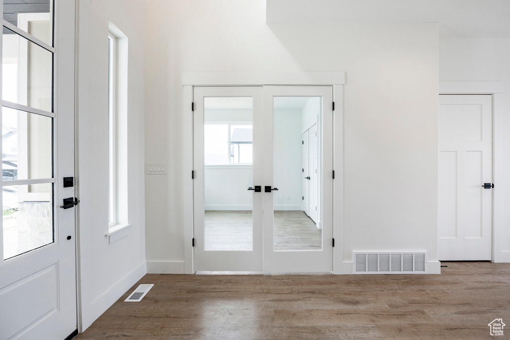 Foyer entrance featuring french doors and wood finished floors