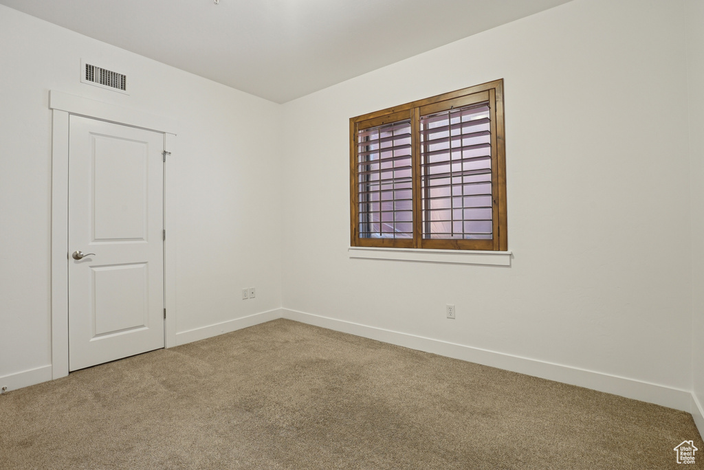 Empty room with carpet flooring and baseboards