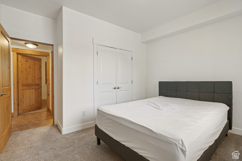 Carpeted bedroom featuring baseboards and a closet
