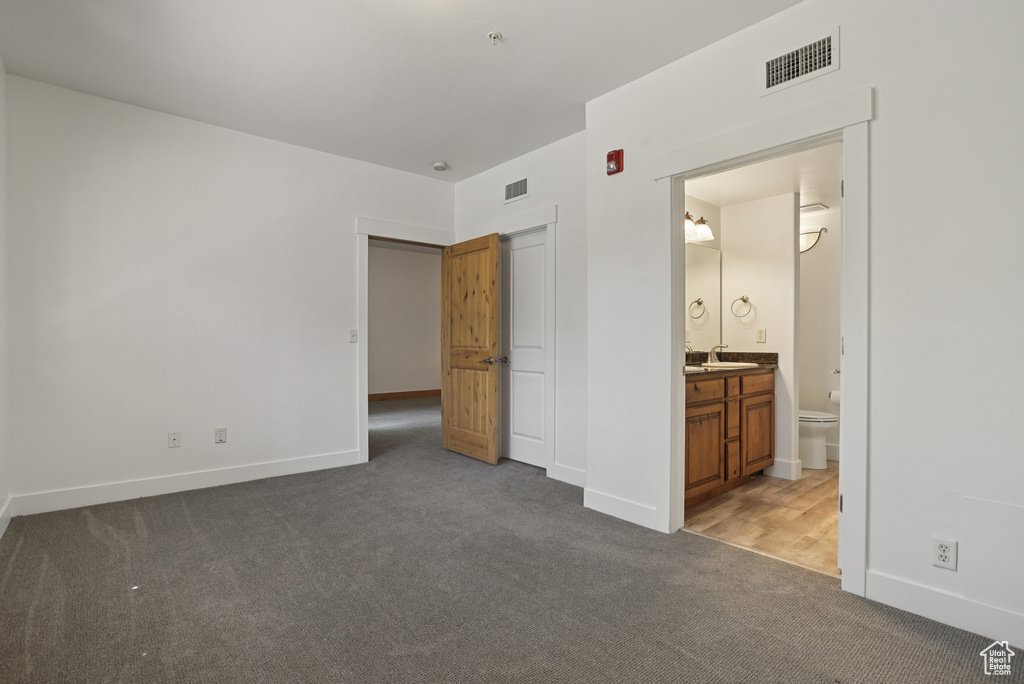 Unfurnished bedroom with carpet flooring and ensuite bathroom