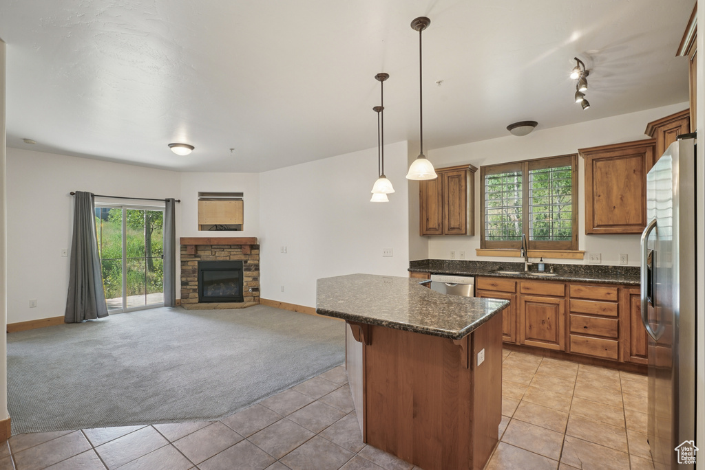 Kitchen featuring light colored carpet, appliances with stainless steel finishes, open floor plan, and plenty of natural light