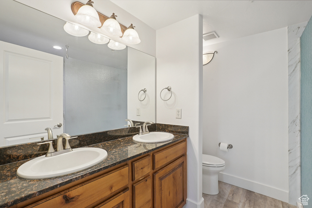 Full bathroom featuring wood finished floors and double vanity