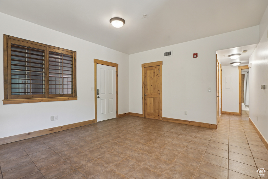 Unfurnished room with baseboards and fire sprinkler in ceiling