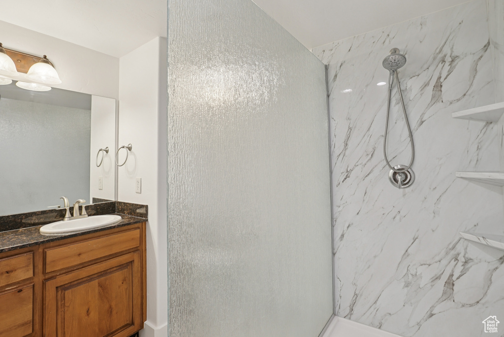 Full bathroom with a marble finish shower and vanity