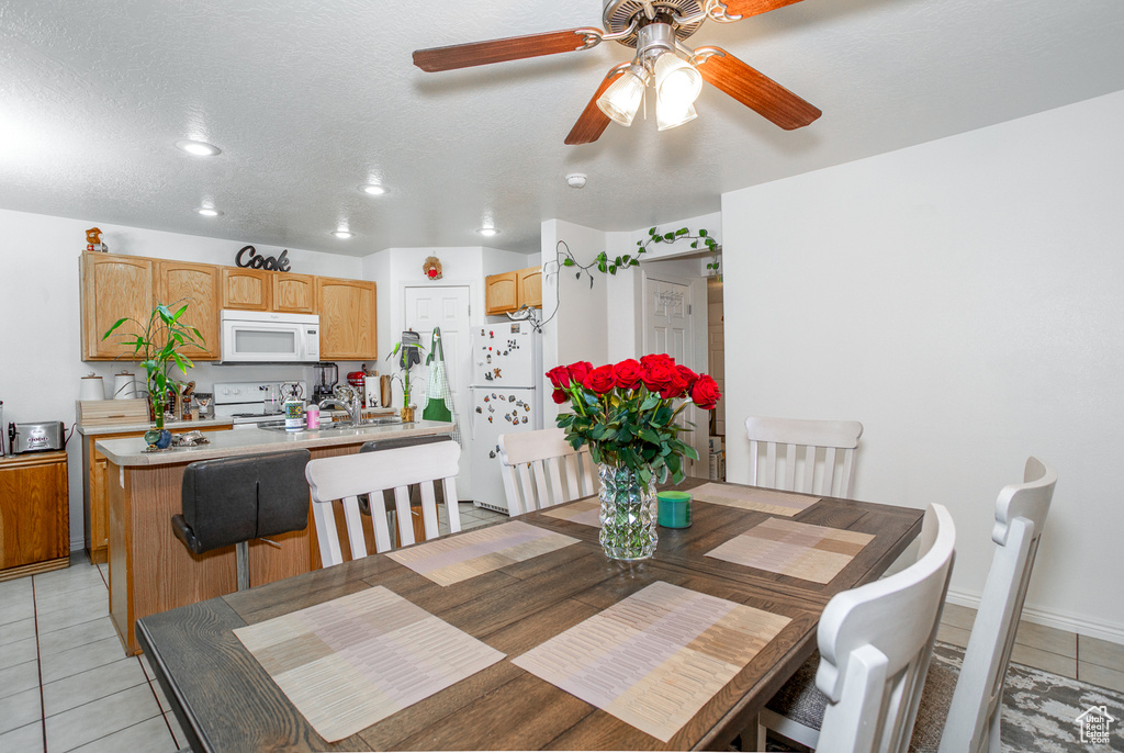 Dining space featuring light tile patterned flooring and ceiling fan