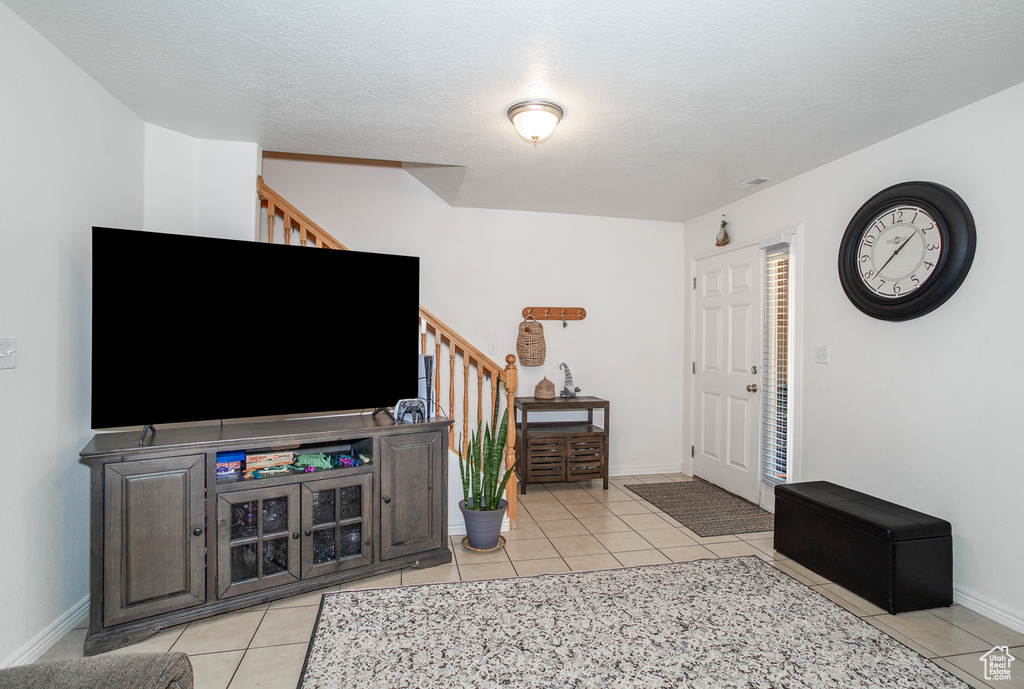 Living area with stairs and light tile patterned floors