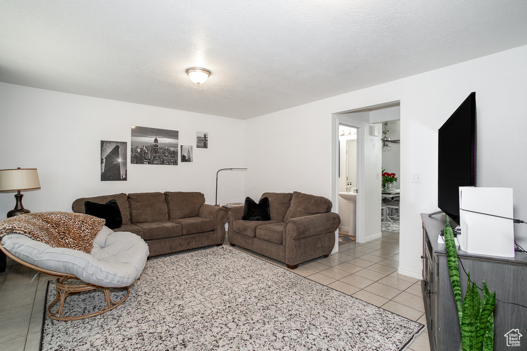 Living area with light tile patterned floors and a ceiling fan