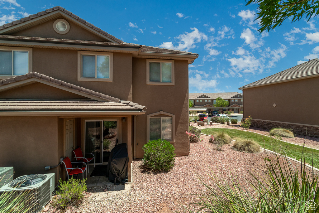 Back of property with stucco siding and a tiled roof