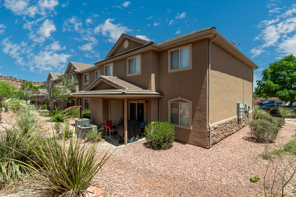 Back of property with a patio area, stucco siding, and a tiled roof