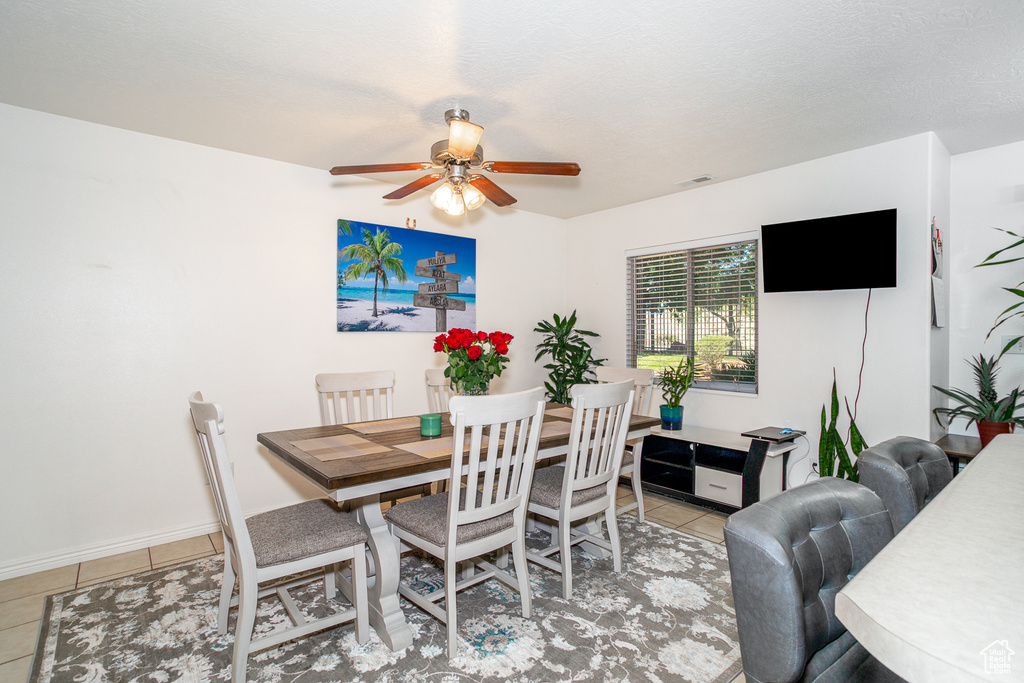 Dining space featuring ceiling fan and light tile patterned flooring