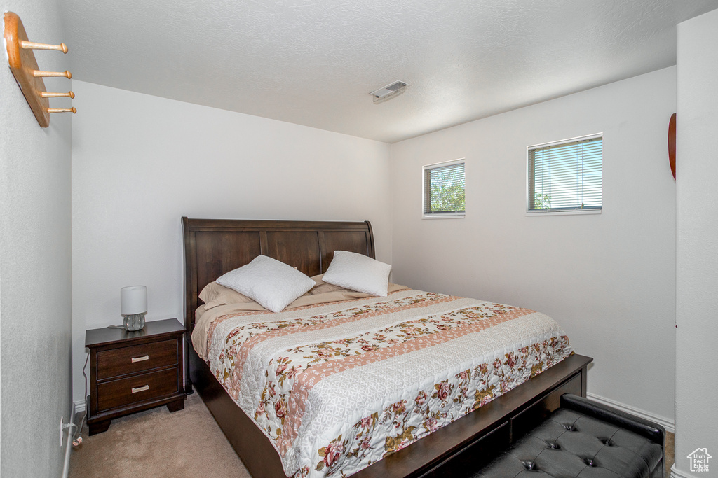 Bedroom featuring light colored carpet and baseboards
