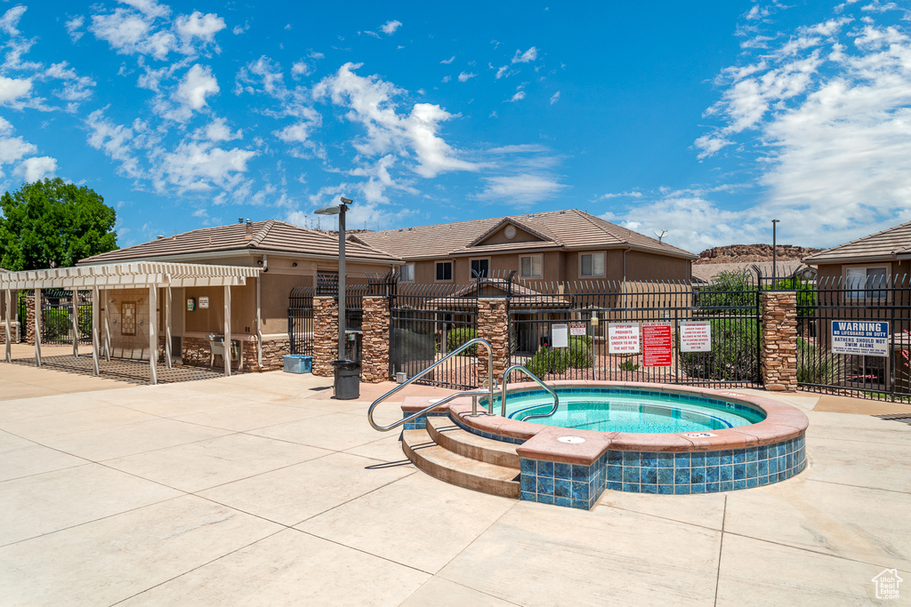 View of swimming pool with a community hot tub and a pergola