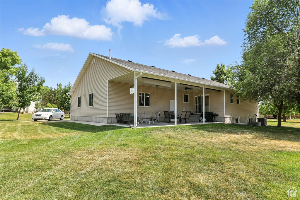 Back of house with a patio, a lawn, and ceiling fan