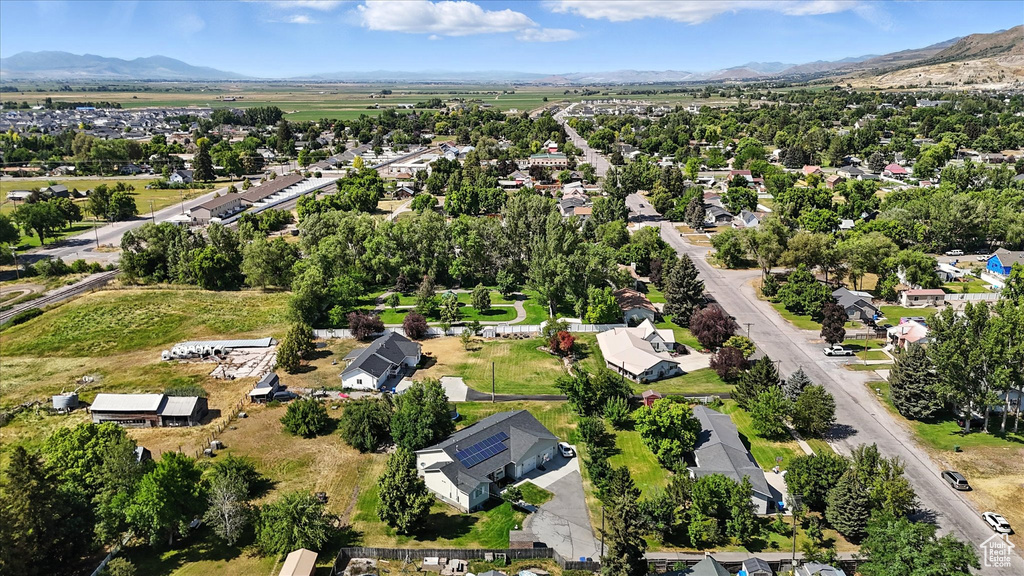 Aerial view of property and surrounding area with a mountain backdrop and nearby suburban area