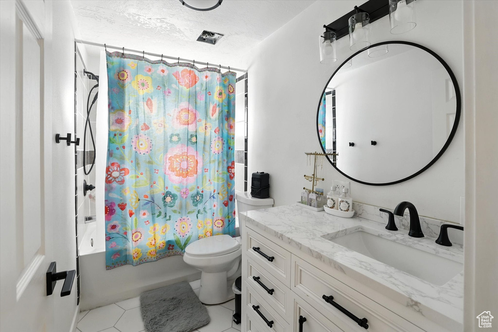 Full bathroom featuring vanity, shower / tub combo, and tile patterned flooring