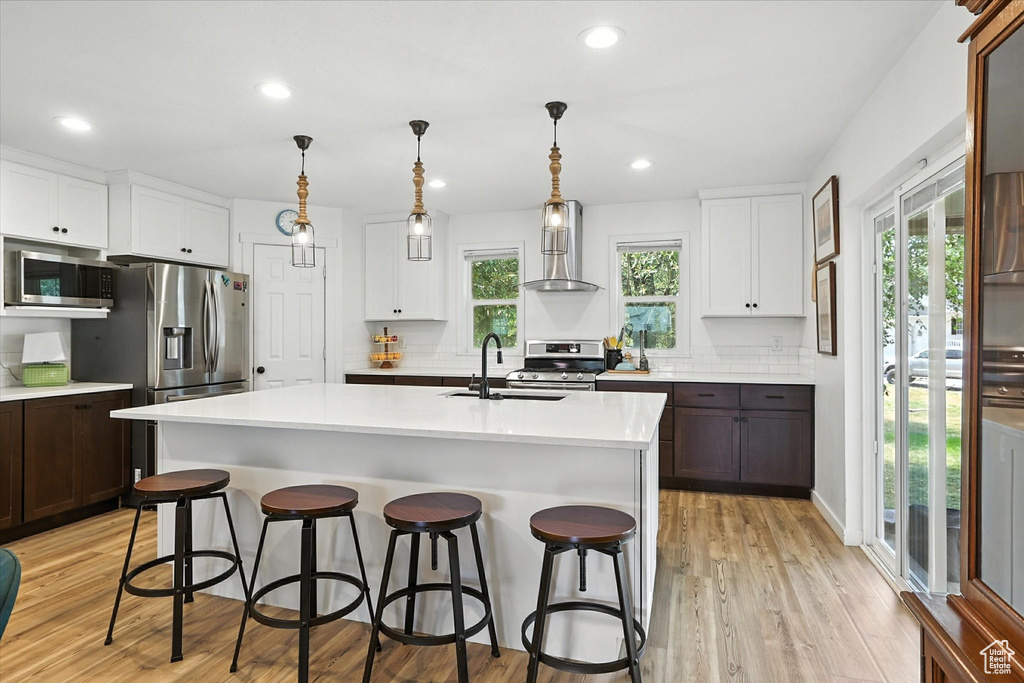 Kitchen featuring stainless steel appliances, light countertops, light wood-style flooring, plenty of natural light, and recessed lighting