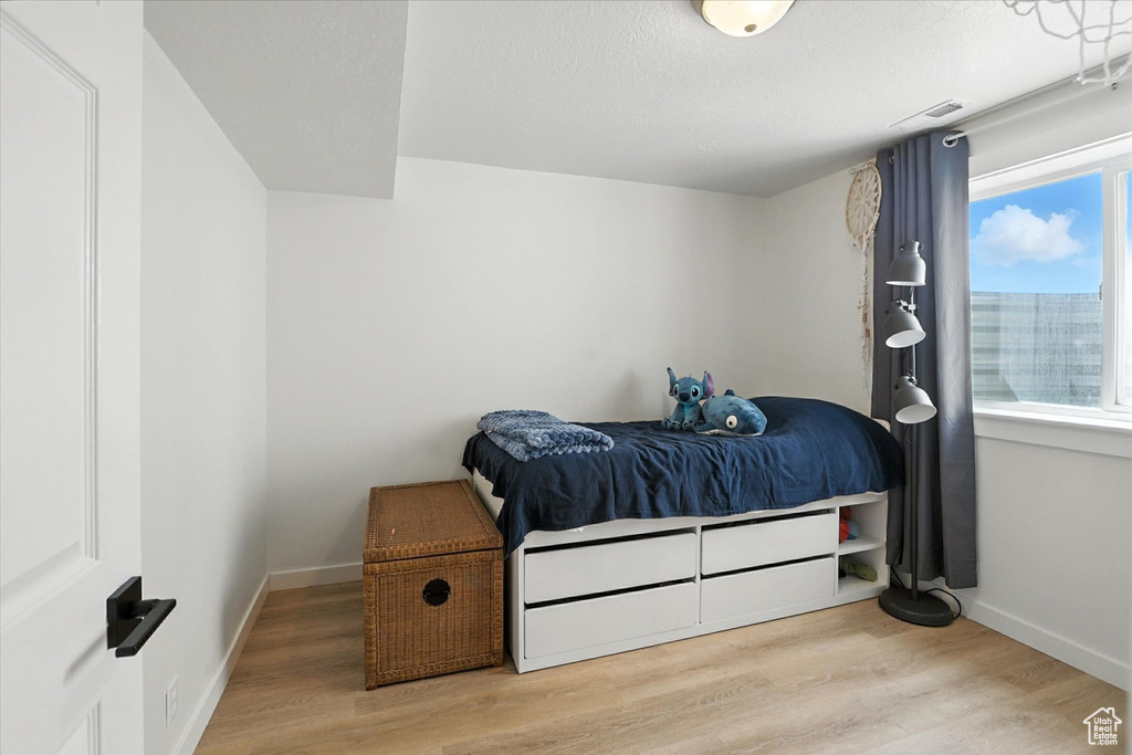 Bedroom with wood finished floors and baseboards